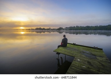 Hiker looking at  sunrise over the lake