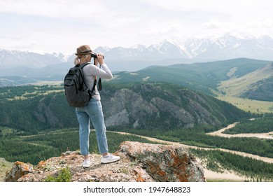 Hiker Looking Through Binoculars On Peak Of Mountain. Travel And Active Lifestyle Concept. - Powered by Shutterstock