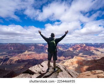 Hiker man with arms raised up above his head on top of the mountain. Climber arms up outstretched on mountain top looking at inspiring landscape. South Rim. Grand Canyon National Park, Arizona, USA. - Powered by Shutterstock