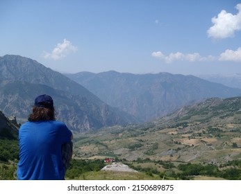 A Hiker Man Sitting And Watching The Landscape Of North Albanian Mountains.