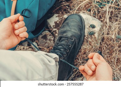 Hiker man tying shoelaces on nature outdoor, near backpack. Point of view shot - Powered by Shutterstock