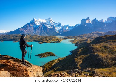 Hiker at mirador condor enjoying amazing view of Los Cuernos rocks and Lake Pehoe in Torres del Paine national park, Patagonia, Chile
