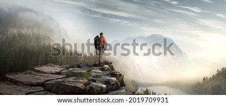 Hiker in mountain landscape enjoys sunrise