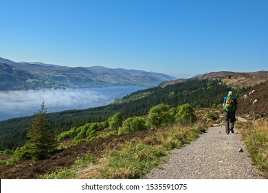Hiker on the "Great Glen Way" in Scotland, with Scottish highlands and loch in the distance - Shutterstock ID 1535591075