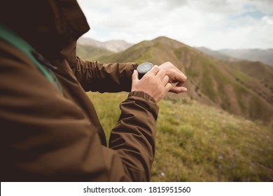 Hiker on high altitude mountain top checking the sports watch  - Powered by Shutterstock