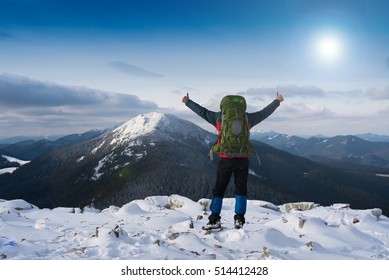 Hiker on the mountain top. Sport and active life concept. Man on peak of mountain. Emotional scene. Hiker at the top of a rock with backpack enjoy sunny day.Thumbs-up, Hiker smiling. 