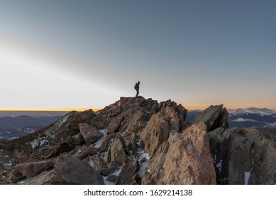 Hiker On Summit Of Twin Sisters Peak In Rocky Mountain National Park, Colorado, Winter, Sunrise