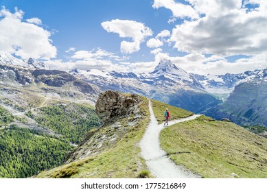 Hiker on a trail choosing one path over another in a beautiful mountain scenery, as a metaphorical decision - Shutterstock ID 1775216849