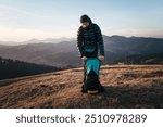 Hiker Packing Backpack on Mountain Ridge