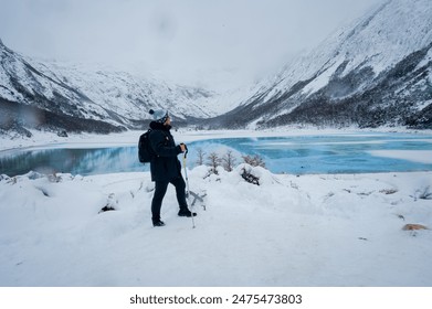 Hiker photographer in snowy mountains in ushuaia emerald lagoon - Powered by Shutterstock