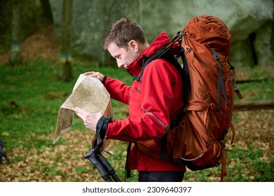 Hiker in red sportswear and huge backpack travelling in mountains with a map. - Powered by Shutterstock