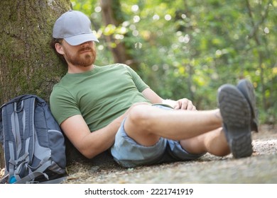 Hiker Sitting On A Tree And Resting