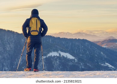 Hiker In Snow Gear Enjoying The View Of Winter Landscape At Sunset Time