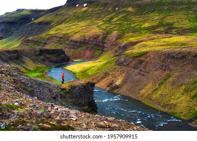 Hiker standing at the edge of the Laxa i Kjos river near Reykjavik in Iceland