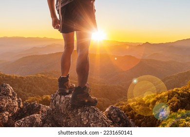 Hiker standing on top mountain sunset background. Hiker men's hiking living healthy active lifestyle. - Powered by Shutterstock