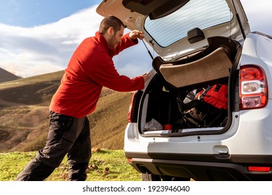 Hiker Thrown His Backpack Out Of The Trunk Of His SUV Car. After A Long Day Of Hiking In The Mountains. Active Turism. Activities In Nature. Escape The Routine