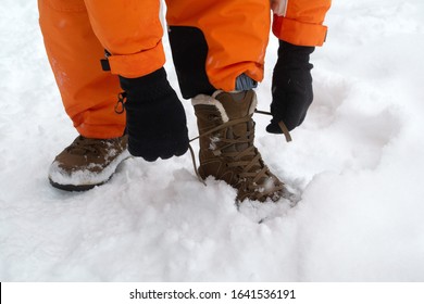 Hiker Tying Shoelaces On Hiking Boots In The Winter