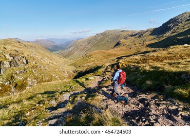 A Hiker Walking Down Towards Seathwaite, Grains Gill From Scafell Pike In The English Lake District. UK.