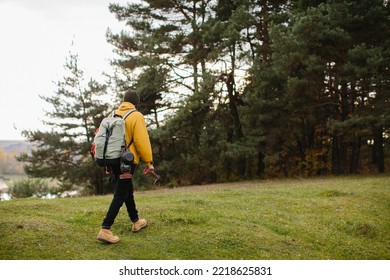 A hiker walking in nature carrying backpack - Powered by Shutterstock