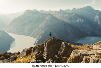 Hiker watching to Sun at horizon. Beautiful moment the miracle of nature. Colorful mist in valley. Man hike. Mountain Pass in Switzerland. Autumn mood at sunset. - Powered by Shutterstock