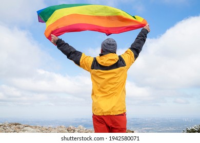 Hiker Waving A Rainbow Lgbt Pride Flag In High Mountains. Inclusive Sport. Mountain Activities