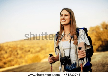 Hiker woman with backpack and sleeping bag walking in the mountains in summer at sunset