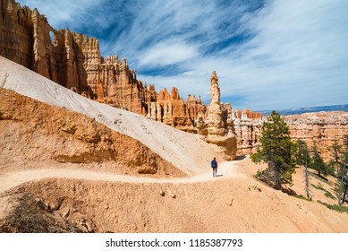 Hiker Woman In Bryce Canyon Hiking Looking And Enjoying View During Her Hike Wearing Hikers Backpack. Bryce Canyon National Park Landscape, Utah, United States.