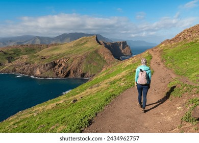 Hiker woman with panoramic view of majestic Atlantic Ocean coastline at Ponta de Sao Lourenco peninsula, Canical, Madeira island, Portugal, Europe. Coastal hiking trail along steep rocky rugged cliffs - Powered by Shutterstock