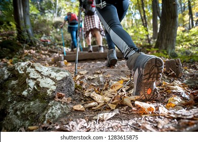 Mujer senderista con bastones trekking sube empinadamente por el sendero de montaña, se centra en el botín