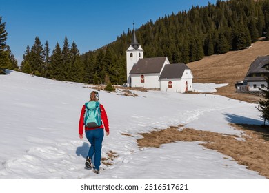 Hiker woman walking to remote church Maria Schnee on Gleinalpe, Lavantal Alps, Styria, Austria. Landmark nestled amidst mountainous landscape, snow-covered hills and dense pine forests. Tranquility - Powered by Shutterstock