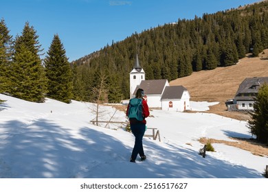 Hiker woman walking to remote church Maria Schnee on Gleinalpe, Lavantal Alps, Styria, Austria. Landmark nestled amidst mountainous landscape, snow-covered hills and dense pine forests. Tranquility - Powered by Shutterstock