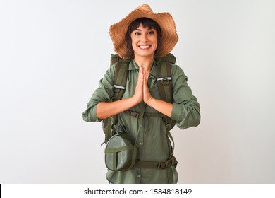 Hiker Woman Wearing Backpack Hat And Water Canteen Over Isolated White Background Praying With Hands Together Asking For Forgiveness Smiling Confident.