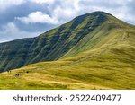 Hikers ascending Pen-y-Fan in the Brecon Beacons from the Cwm Gwdi ridge on the north side