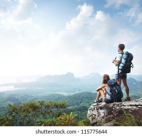 Hikers with backpacks enjoying valley view from top of a mountain - Powered by Shutterstock