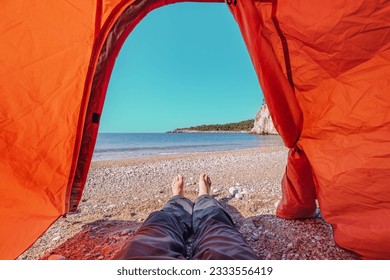 a hiker's barefoot legs inside a camping tent set up on a wild sandy beach along the Lycian Way. - Powered by Shutterstock