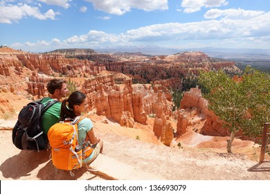 Hikers in Bryce Canyon resting enjoying view Hiking couple in beautiful nature landscape with hoodoos, pinnacles and spires rock formations. Bryce Canyon National Park, Utah, USA in summer. - Powered by Shutterstock