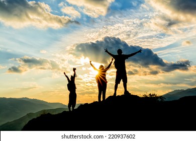 hikers celebrating success on top of a hill in the sunset - Powered by Shutterstock