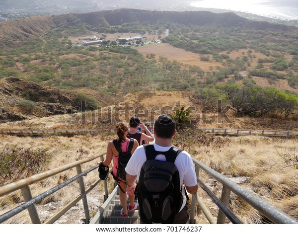 Hikers climbing down stairs\
leaving the lookout at Diamond Head Crater lookout on Oahu, Hawaii.\
