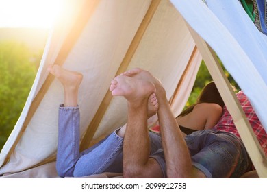 Hikers couple camping on nature. Back legs view of couple in tent. Best friend. Focus on feet. Romantic lovers on vacation camping in tent. Couples lovers camping in forest in summer time.