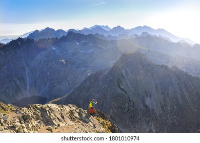 Hikers enjoying majestic views of mountains. High Tatras national park, Kriváň peak. Hot summer day with blue sky. 