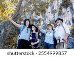 Hikers or explorers happy on journey carrying backpack, trekking poles looks into selfie smartphone observing and possibly guide trekking and trail exploration holiday ecotourism concept.