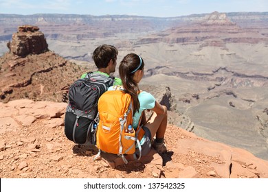 Hikers In Grand Canyon Enjoying View Of Nature Landscape. Young Couple Hiking Relaxing During Hike On South Kaibab Trail, South Rim Of Grand Canyon, Arizona, USA.