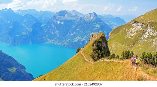 Hikers on the ridge walk along Lake Lucerne near Stoos, Switzerland, between Klingenstock and Fronalpstock  with impressive views on the Alps