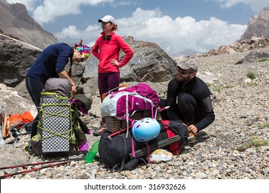 Hikers Packing Backpacks Group Of People Man And Women Sitting Staying Along With Large Bags With Climbing Gear Attached Such As Helmet Camping Mat Walking Poles Ice Axe