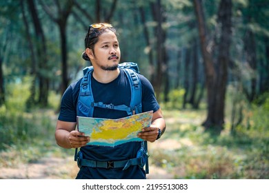 Hikers reading a map while trekking in nature. Nature. Lifestyle. People and leisure time concept. Men hikers are looking for destinations on the map.