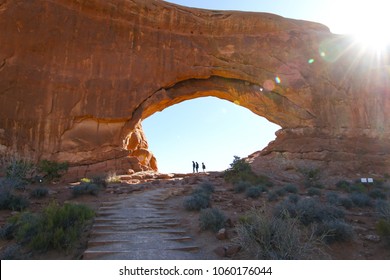 Hikers Silhouetted Inside North Window Arch At Arches National Park In Moab Utah 