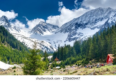 Hikers Spending Time Together At A Mountain Cabin Deep In The Snowy Mountains In A Wild Green Forest