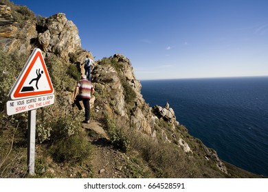 Hikers Walking on a Dangerous Coastal Trail - Powered by Shutterstock