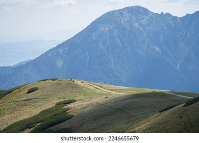 Hikers walking the ridge with big mountain in backdrop, Slovakia, Europe - Shutterstock ID 2246655679