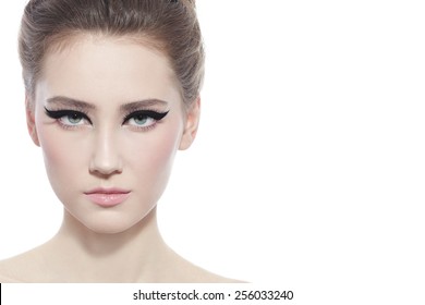 Hi-key portrait of young beautiful girl with stylish cat eye make-up over white background